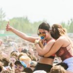 Music Festival - Two Women Embracing Surrounded by Crowd
