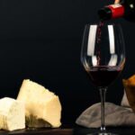 Wine Tasting - Photo of Person Pouring Wine into Glass besides Some Cheese Pairings