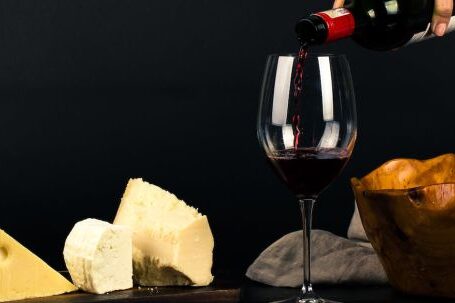 Wine Tasting - Photo of Person Pouring Wine into Glass besides Some Cheese Pairings